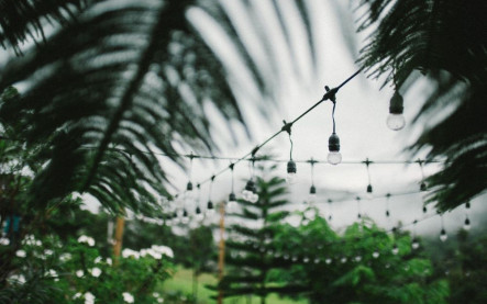 Večerná záhrada osvetlená solárnymi lampami a LED svetlami pri chodníku